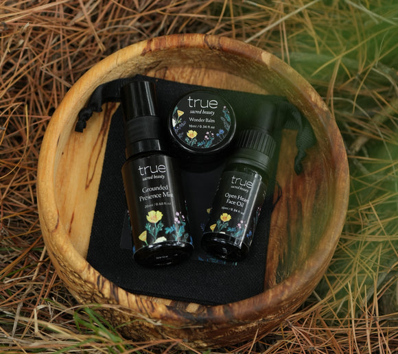 Set of 'true' skincare products in a wooden bowl on a natural background