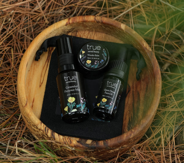 Set of 'true' skincare products in a wooden bowl on a natural background